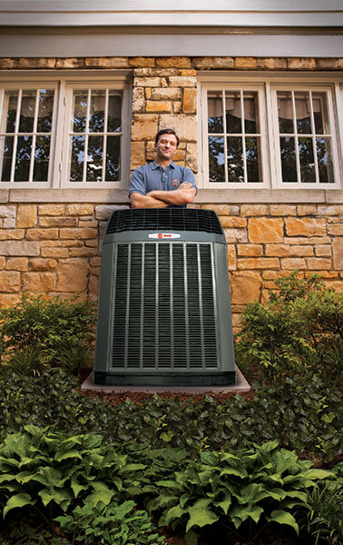 Tech standing behind trane unit